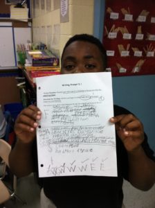 student holding writing feedback paper