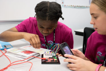 two female students working with circuit board
