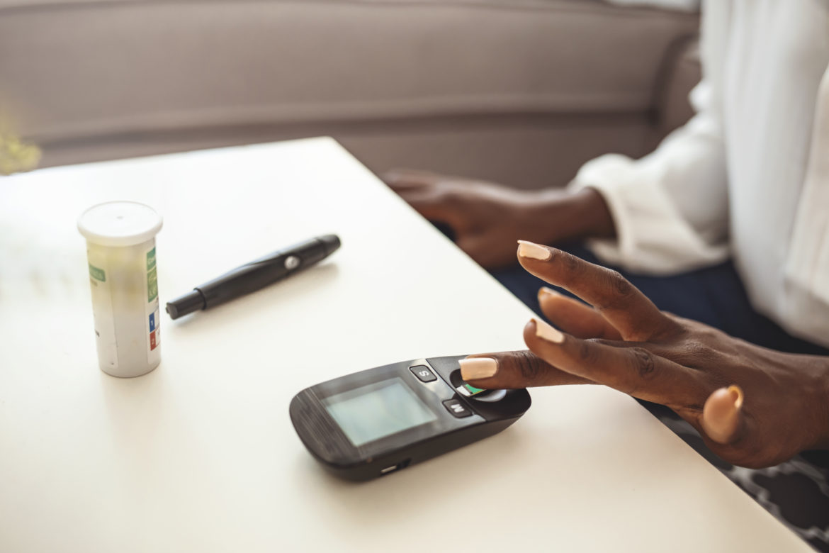 Closeup shot of a Black woman testing her blood sugar level