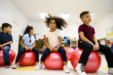 elementary students on stability ball in classroom