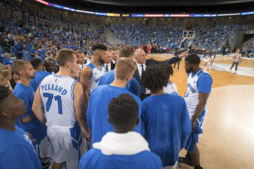 Coach giving instructions to basketball team during the match