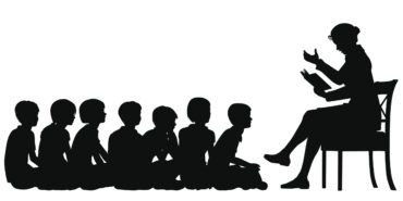 silhouettes of a female teacher reading a story to her students