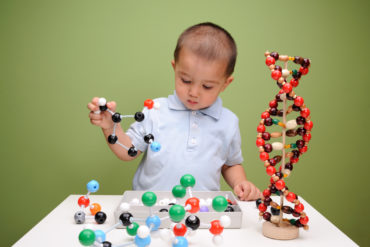 Child playing with molecular structures and DNA model