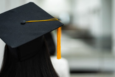 Graduate faced away from camera with graduation cap on