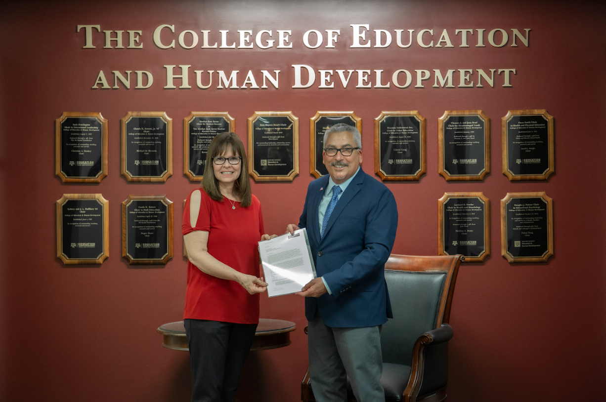 Dr. Michael A. de Miranda presents Dr. Sharon Matthews with Professorship award letter