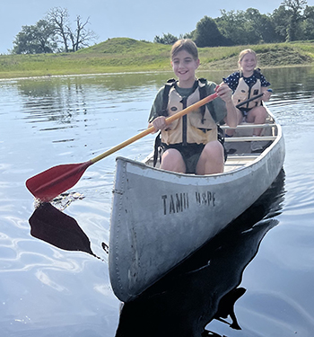 Two campers canoeing while attending Camp Adventure.