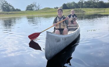 Two campers canoeing while attending Camp Adventure.