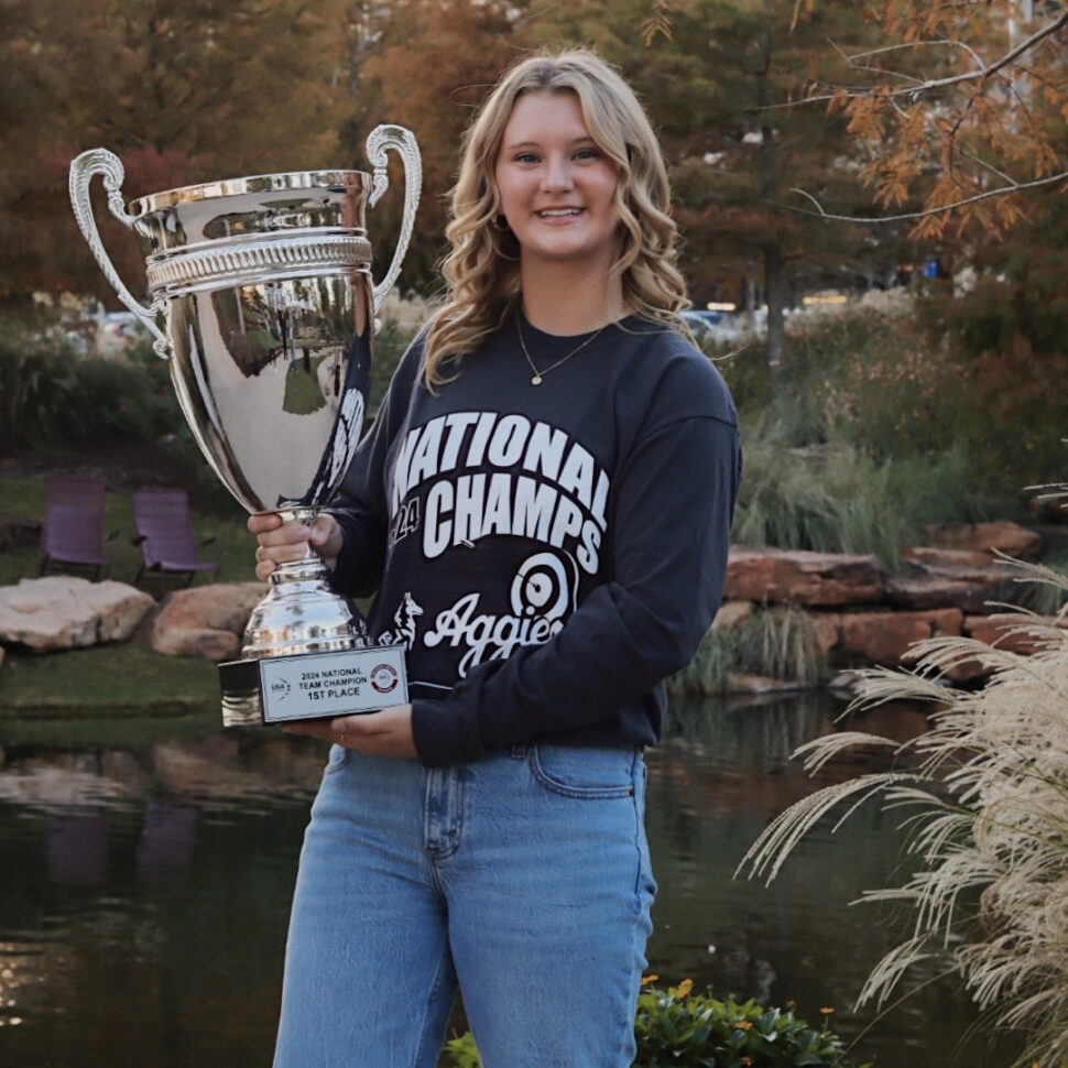 Riley Marx poses with the Archery National Champions Trophy at Aggie Park