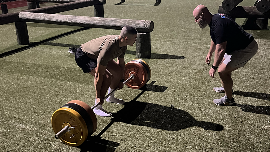 Program Director Nate Young coaching program participant in weightlifting exercise.