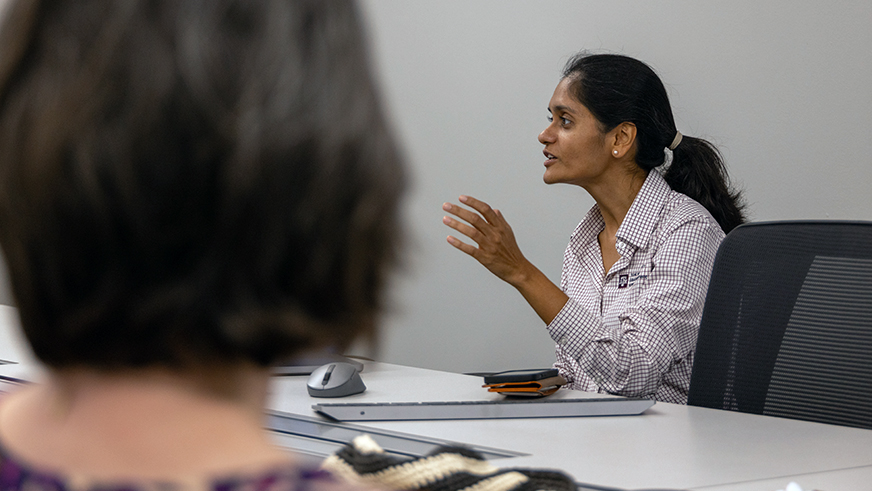 Dr. Ananya Tiwari sitting at a table in the middle of a presentation.