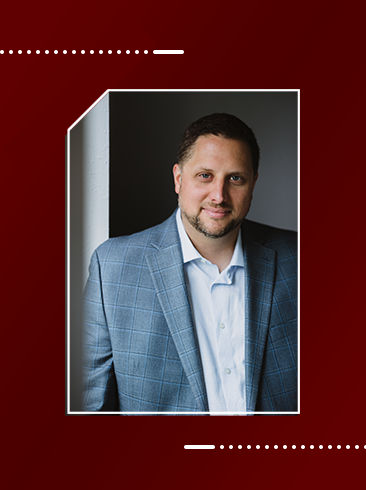 Photo of Dr. Daniel Hajovsky with maroon background.